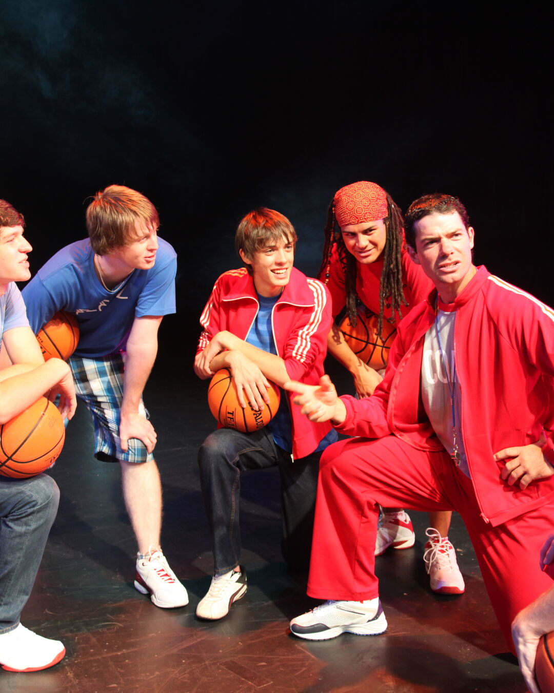 Performers acting out Basketball huddle during performance.