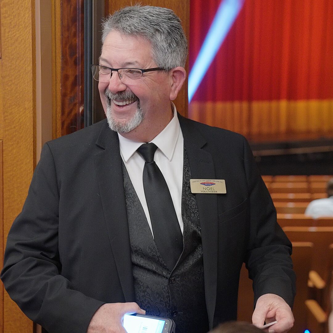 Smiling usher scanning patrons' tickets