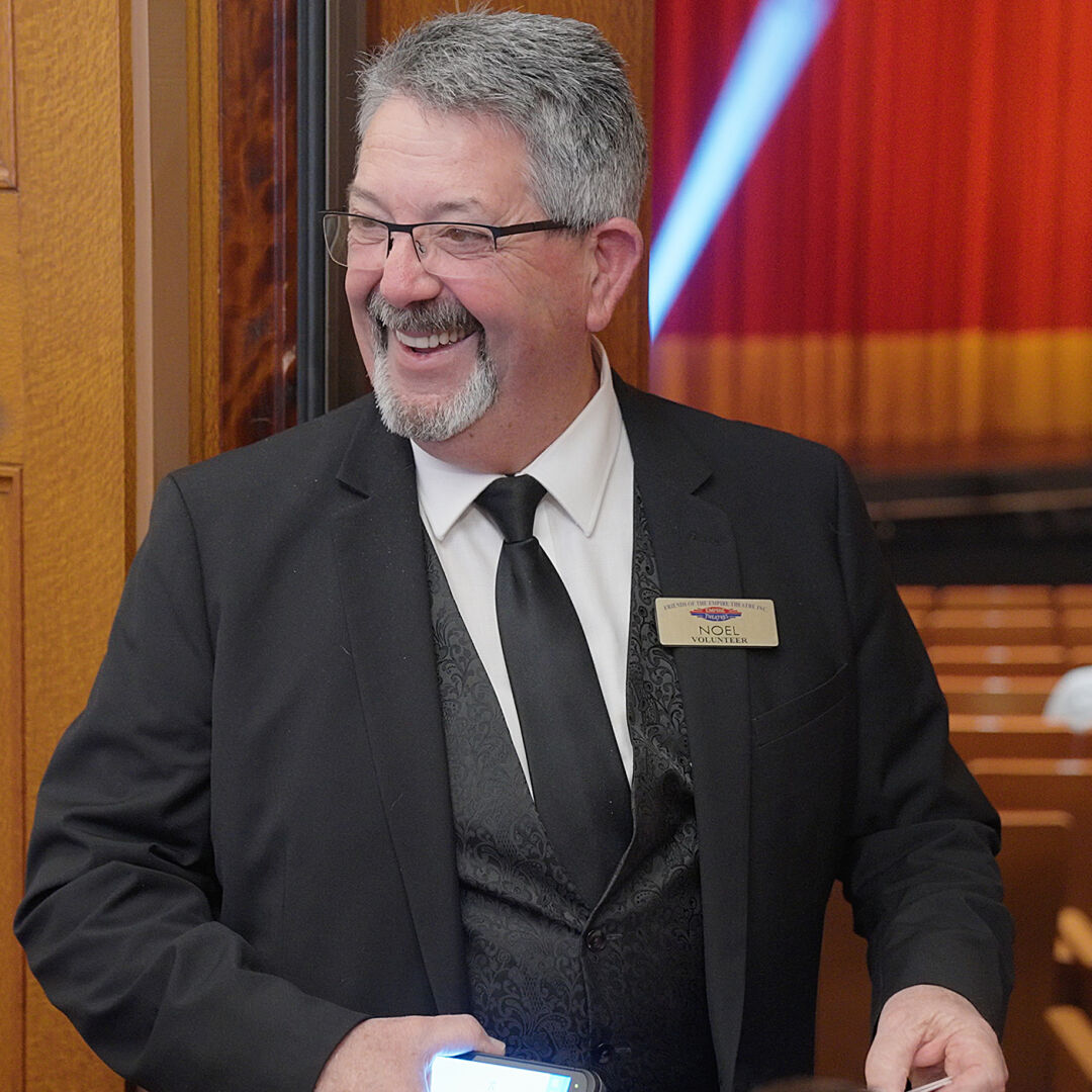 Smiling usher scanning patrons' tickets