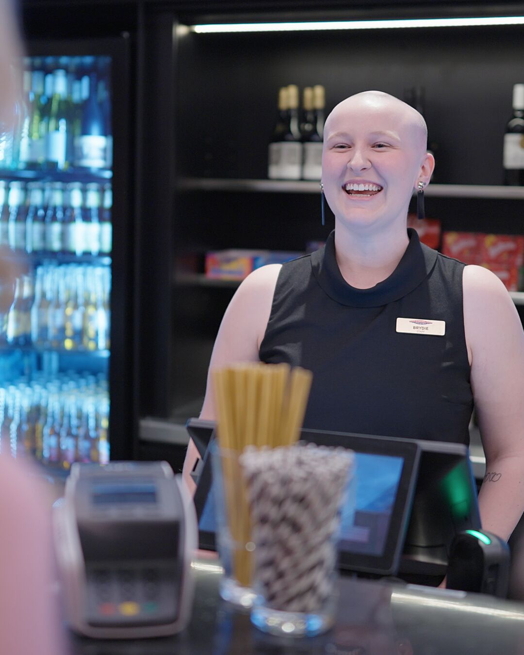 Bar staff greeting customers. 