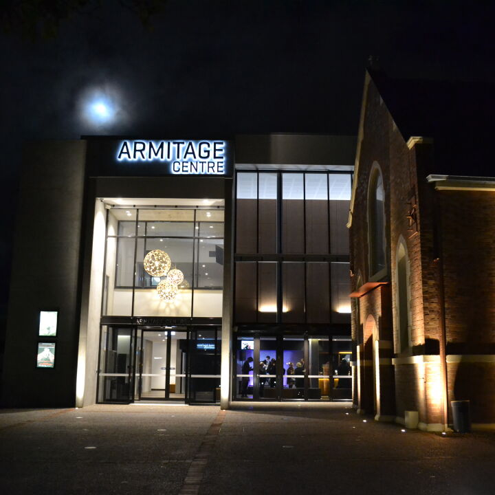 Facade of Armitage centre at night with lights on in foyers